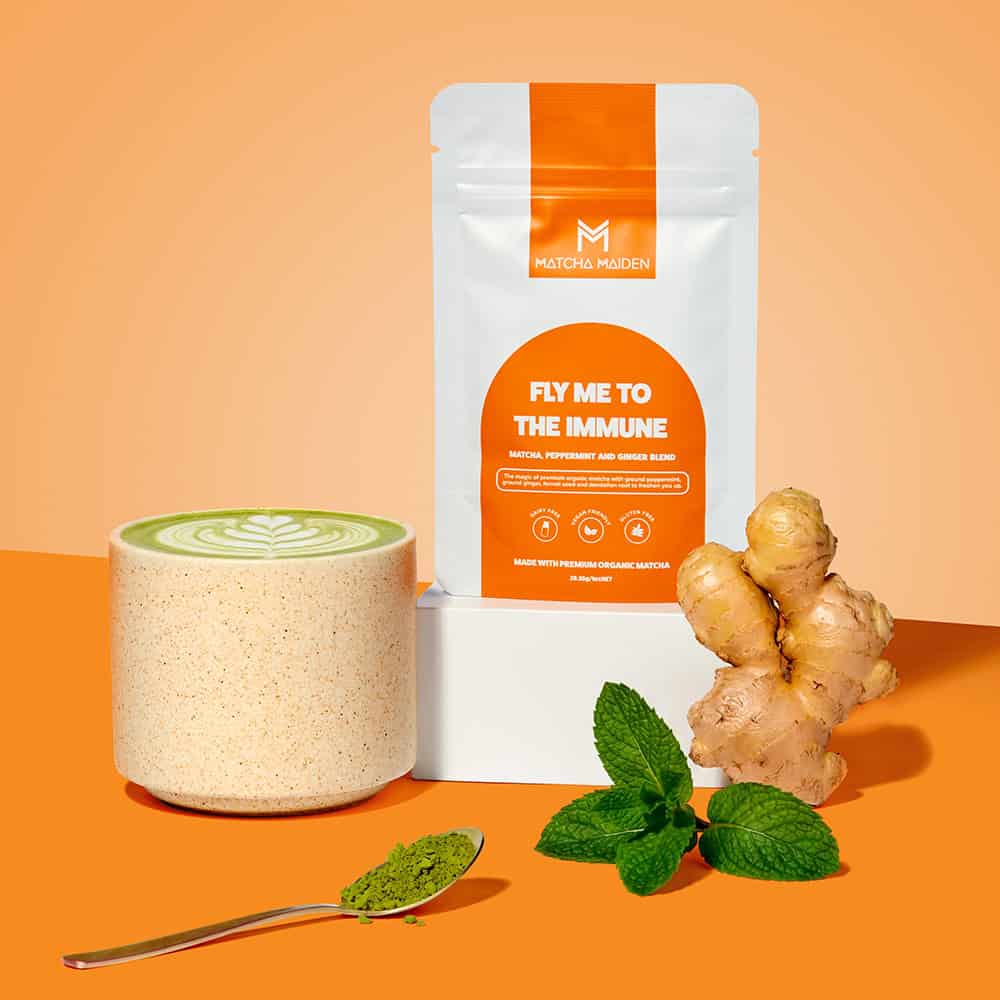 Matcha Maiden Fly Me To The Immune matcha, peppermint, and ginger blend pouch with hot latte, fresh ginger root, and mint.