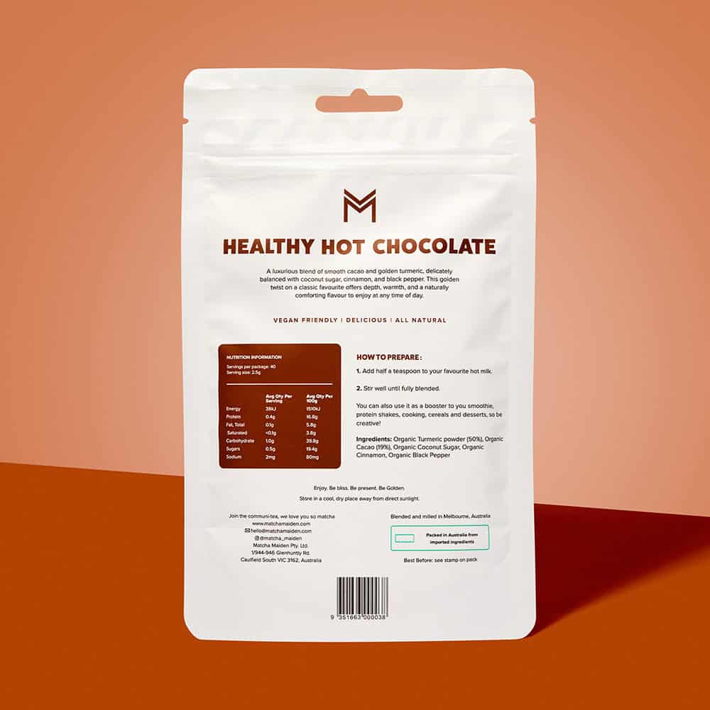 Golden Grind Turmeric Healthy Hot Chocolate 100g pouch showing nutrition & prep on a warm brown and red background.